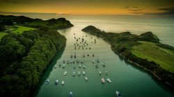 Watermouth Cove at sunset over water with small boats.