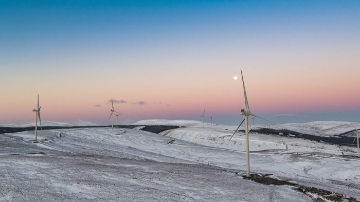 misty sunrise at dawn on a snowy wind farm