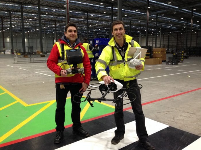 filming Indoors with a drone. Cameraman Ian Fearnley and Drone Pilot Phil Fearnley. Dressed in His Visibility safety clothing. Filming in a large warehouse