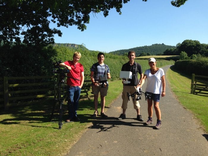 Multi drone crew team photo with crew at Daisybeck studios holding the Drone. country side with fields are all around whilst filmed in the summer