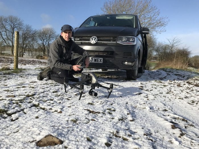 Pilot with drone and VW Transporter and snow