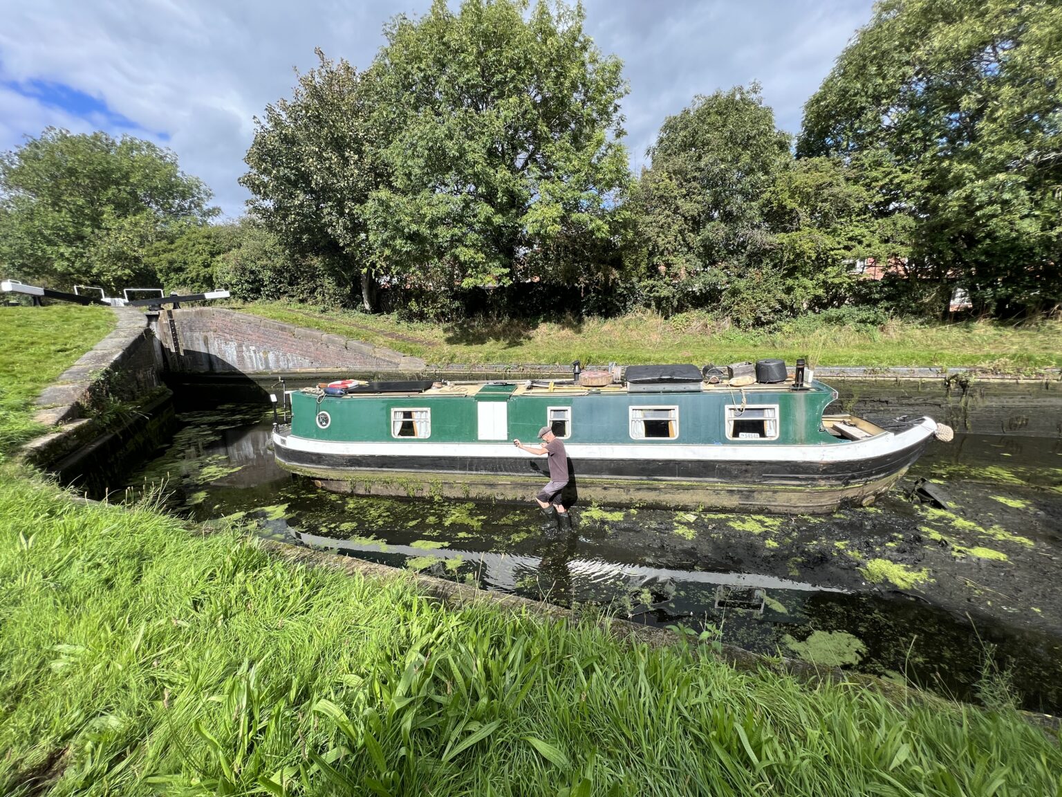 Robbie Cumming beside the Naughty Lass in an emptied lock pound, Canal Boat Diaries