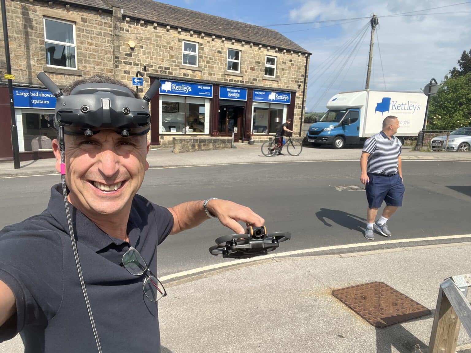 Phil Fearnley wearing FPV goggles, holding a small FPV drone