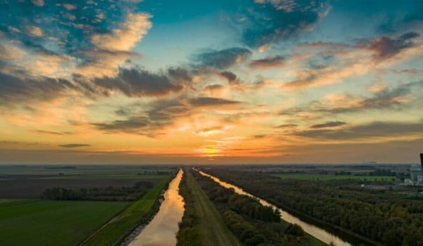 Drone over two rivers at sunset featuring bright lit up sky.