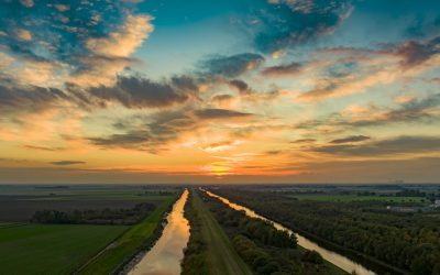 drone over two rivers at sunset featuring bright lit up sky.