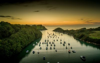 Watermouth Cove at sunset over water with small boats.