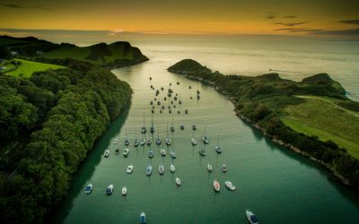 Watermouth Cove at sunset over water with small boats.