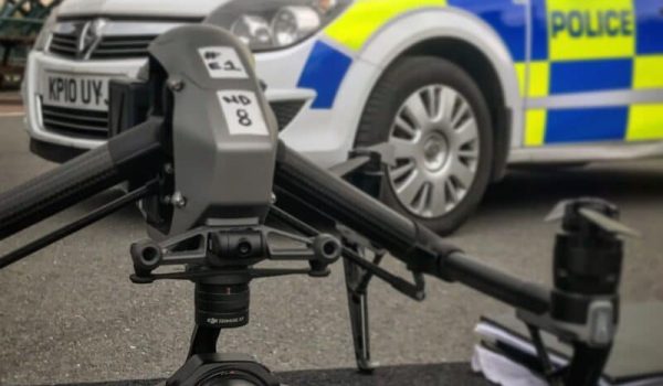 DJI Inspire 2 drone on a work table with a fake police car in the background.